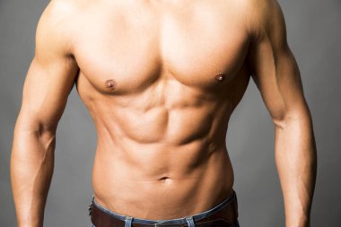 Kaslı vücutlu ve gömleksiz bir adamın portresi.