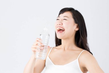 Mutlu Asyalı kadın su içiyor.