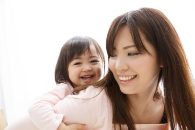 Asyalı anne ve kızı birlikte oynuyorlar.