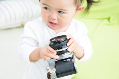 Küçük kız evde kamerayla oynuyor. 