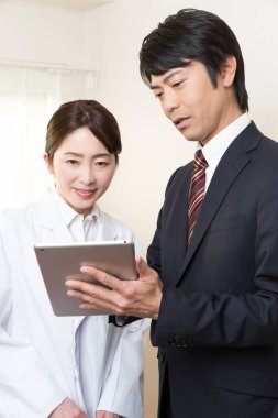 Genç bir işadamının tabletli bir hemşireyle portresi.