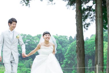 Parkta poz veren Asyalı gelin ve damat 