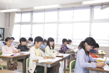 Japon ilkokul öğrencileri sınıfta yazıyor. eğitim kavramı