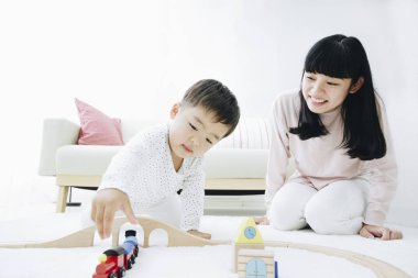 Evde annesiyle oynayan tatlı Japon çocuk.