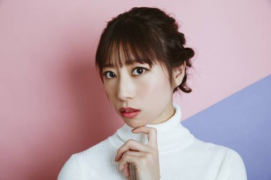 Beyaz kazak giyen Asyalı kadın, stüdyo fotoğrafı. 