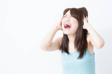 Beyaz arka planda çığlık atan genç Asyalı kadın.