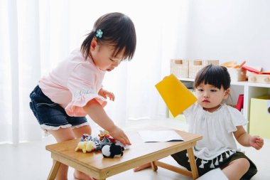 Küçük sevimli Japon kızları oyuncaklarla oynuyorlar.