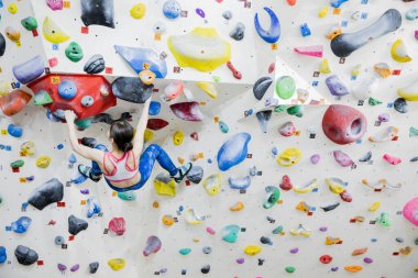 Güzel Japon kadın spor salonunda duvara tırmanıyor. 