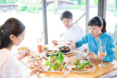 Asyalılar restoranda yemek yiyor. 