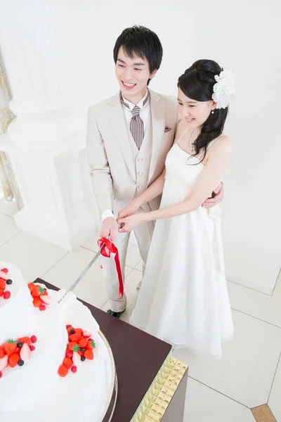 美しい幸せな若い結婚式のカップル一緒にお祝いのケーキをスライス — ストック写真
