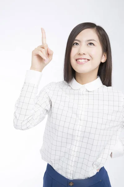 Студійний Знімок Красивої Японської Жінки Дивлячись Вгору Вказуючи Білий Фон — стокове фото
