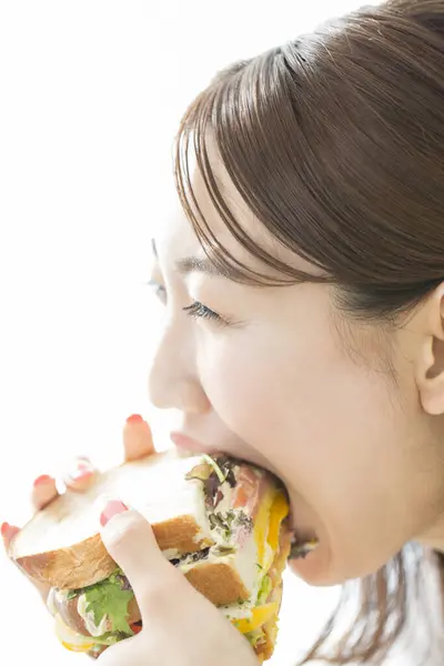 吃美味三明治的年轻亚洲女人 — 图库照片
