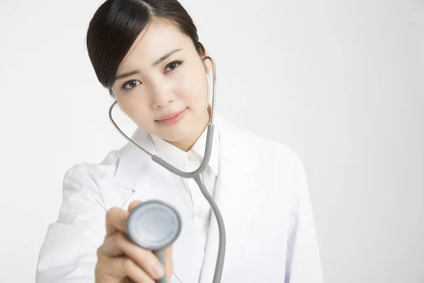 Asiatische Ärztin Hält Ein Stethoskop Auf Weißem Hintergrund — Stockfoto