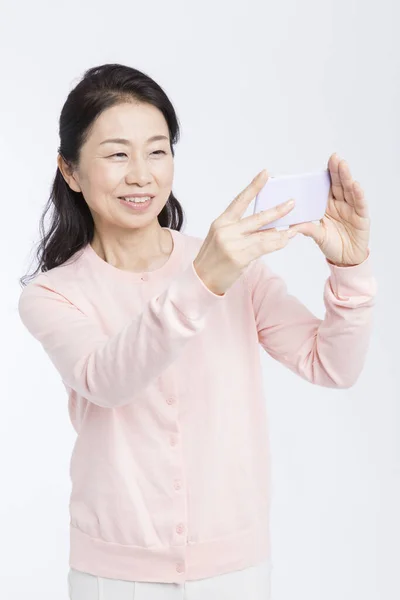 Starszy Azji Kobieta Pomocą Telefon Komórkowy Biorąc Selfie Izolowane Biały — Zdjęcie stockowe