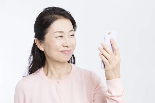 Starszy Kobieta Pomocą Smartfona Izolowane Białym Tle — Zdjęcie stockowe