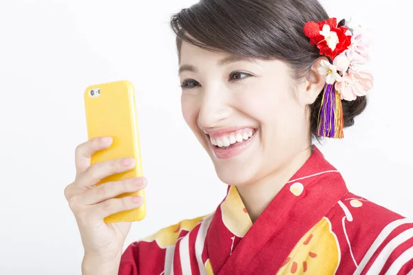 Жінка Японському Кімоно Допомогою Смартфона Усміхненим Обличчям Ізольована Білому Тлі — стокове фото
