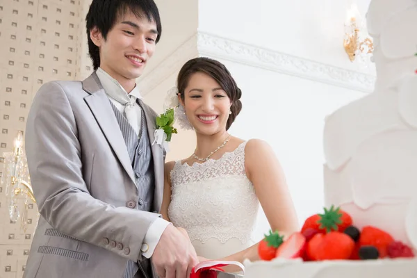 美しい幸せな若い結婚式のカップル一緒にお祝いのケーキをスライス — ストック写真