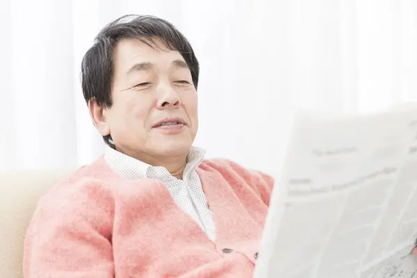 日本老人在家里看报纸 — 图库照片