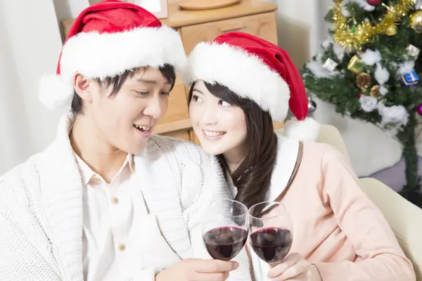 Şarap Kadehleriyle Noel Şapkalı Çift — Stok fotoğraf