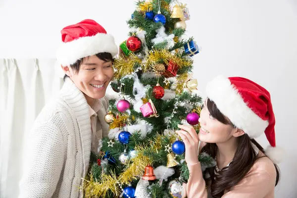 Ευτυχισμένο Νεαρό Ασιατικό Ζευγάρι Στολίζει Χριστουγεννιάτικο Δέντρο — Φωτογραφία Αρχείου