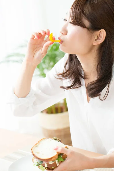 Young Asian Woman Eating Delicious Sandwich — Stock Photo, Image