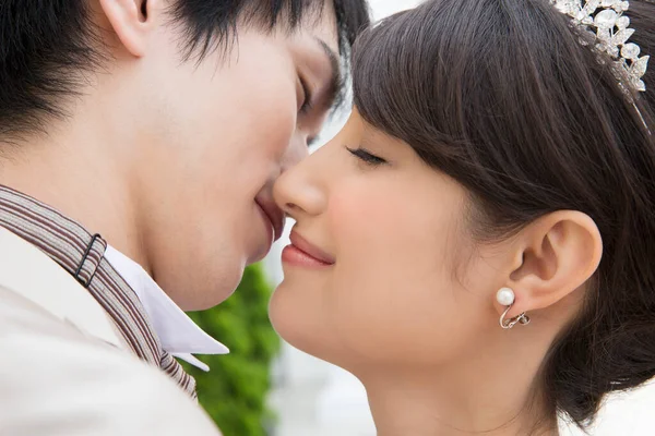 美しい幸せな若いアジアの結婚式のカップルの肖像画 屋外でキス — ストック写真