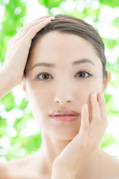 young Asian woman touching face with hands, skin care and beauty concept