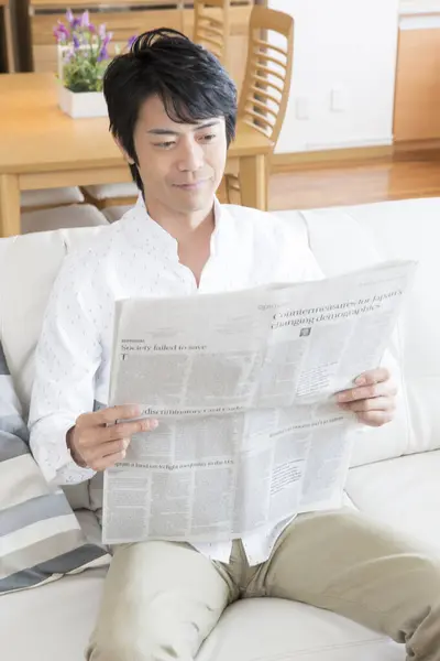 亚洲人在家看报纸 — 图库照片