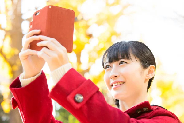 在公园用手机的日本女人 — 图库照片