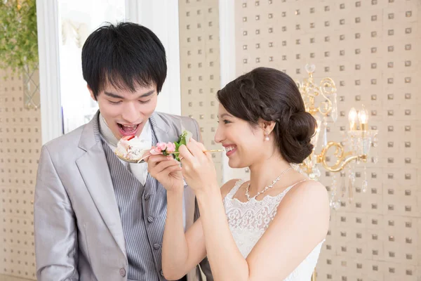 結婚式のケーキが付いている美しい幸せな若い花嫁の餌のハンサム グロム — ストック写真