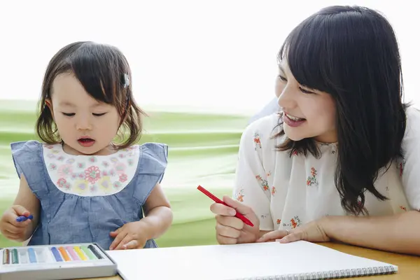 自宅で母親と描くかわいいアジアの少女 — ストック写真