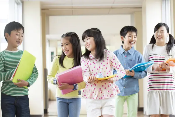Okul Koridorunda Yürüyen Kitaplarla Bir Grup Japon Çocuk — Stok fotoğraf