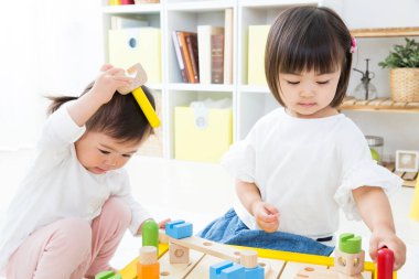 İki genç kız renkli oyuncaklarla oynuyorlar.