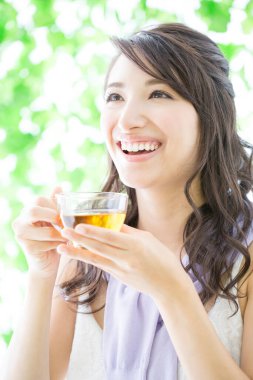 Bahçede çay içen genç bir kadın