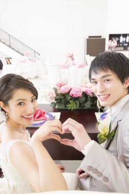 Güzel, genç bir çift kalp hareketi yapıyor.  