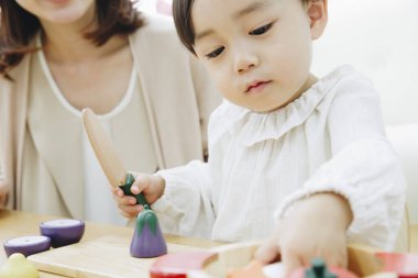 Evde annesiyle oynayan tatlı Asyalı kız.