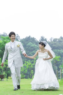 Parkta poz veren Asyalı gelin ve damat 