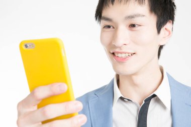 Cep telefonlu genç adam beyaz arka planda izole edildi.