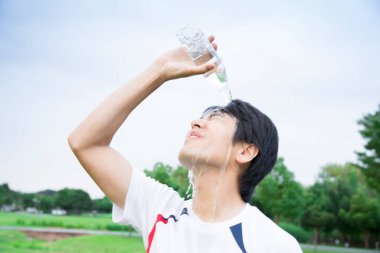 Koşu yaptıktan sonra kendine su döken genç bir adamın portresi.