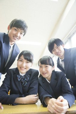 Üniformalı gülümseyen öğrenciler birlikte poz veriyorlar.