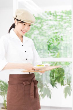 Ziyaretçilere yemek servisi yapan Asyalı garson. 