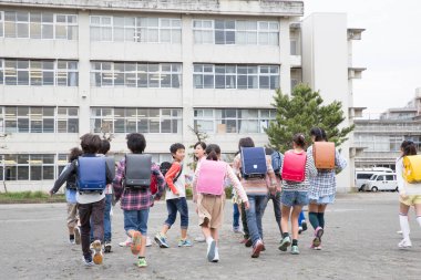 Japon okul çocukları okula koşuyor.  