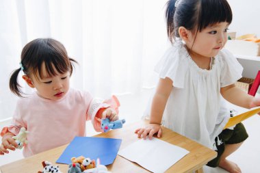 Küçük sevimli Japon kızları oyuncaklarla oynuyorlar.