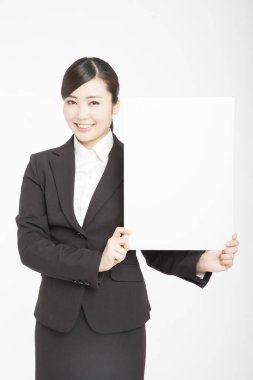 Genç Asyalı kadın beyaz arka planda izole edilmiş boş bir karta uluyor. 