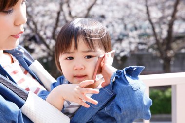 Annesi akıllı telefonlu tatlı bir Japon çocuğunun sokakta portresi.