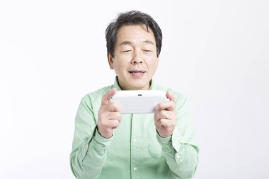 joystick 'i tutan yaşlı Asyalı adam, stüdyo fotoğrafı. 