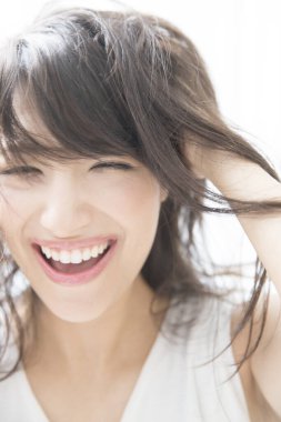 Beyaz arka planda gülümseyen Asyalı kadın