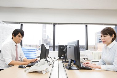 İşadamı ve işkadını ofiste çalışıyor.