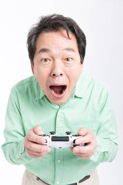 joystick 'i tutan yaşlı Asyalı adam, stüdyo fotoğrafı. 