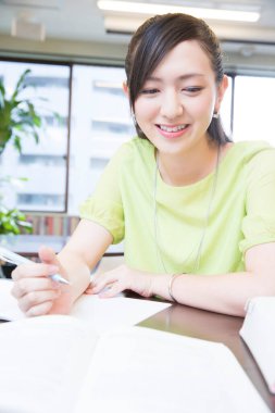 Üniversite kütüphanesindeki genç Asyalı kadın.